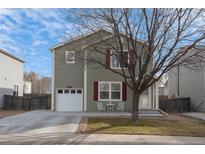 Charming two-story home with red shutters, a front yard, and a single-car garage at 1424 Swan Ave, Brighton, CO 80601