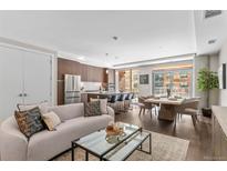 Bright open-concept living room and kitchen boasts hardwood floors and modern finishes at 4200 W 17Th Ave # 211, Denver, CO 80204