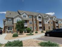 Well maintained apartment building with stone and siding, manicured landscaping, and reserved parking space at 1851 S Dunkirk St # 201, Aurora, CO 80017