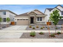 Charming single-Gathering home with stone accents, a manicured yard, and an attached two-car garage at 25283 E Warren Pl, Aurora, CO 80018