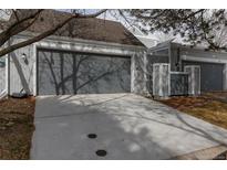 Attached two-car garage featuring a concrete driveway with a grey door for a modern look at 2770 S Elmira St # 42, Denver, CO 80231