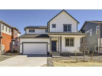 Two-story farmhouse-style home with white siding, gray accents, and a two-car garage at 786 Sawdust Dr, Brighton, CO 80601
