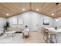 Bright living room with vaulted ceiling, hardwood floors, and modern furniture at 2610 W 90Th Pl, Denver, CO 80260