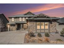 Charming two-story home with stone accents, landscaped yard, and inviting front porch at 8259 Arapahoe Peak St, Littleton, CO 80125