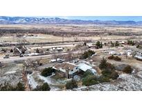 An aerial view of a home near a highway, showcasing mountain views on a snowy day at 7338 W Lakeside Dr, Littleton, CO 80125