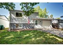Charming two-story home featuring a well-maintained lawn, garage, and welcoming entrance at 4833 S Pitkin Ct, Aurora, CO 80015