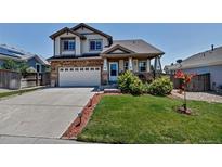 Charming two-story home with a well-manicured lawn and inviting curb appeal in a suburban neighborhood at 16352 E 104Th Way, Commerce City, CO 80022