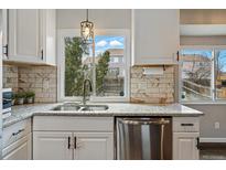 Well-lit kitchen features granite countertops, stainless steel appliances, and a window view to the backyard at 19820 E Amherst Dr, Aurora, CO 80013