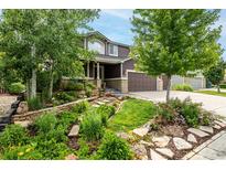 Beautiful two-story home with professional landscaping, including stone pathways and lush greenery at 8410 S Oak St, Littleton, CO 80127