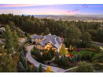 Stunning estate nestled in lush greenery featuring long driveway and mountain views at sunset at 2198 Avenida Del Sol, Castle Rock, CO 80104