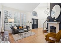 Bright living room boasting high ceilings, a fireplace, and many large windows with plantation shutters at 2187 Wynterbrook Dr, Highlands Ranch, CO 80126