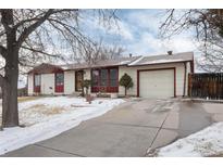 Ranch style home with attached garage and snowy front yard at 401 S Dover Ct, Lakewood, CO 80226