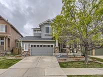 Two-story house with gray siding, stone accents, and a two-car garage at 10468 Wagon Box Cir, Highlands Ranch, CO 80130