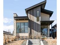 Modern exterior featuring a stone and wood facade, black trim, and an inviting entrance at 4721 Elm Ct, Denver, CO 80211