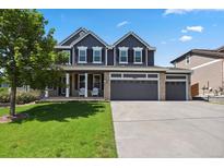 Beautiful two-story home featuring a three car garage, manicured lawn, and charming curb appeal at 19653 E Ida Dr, Aurora, CO 80015
