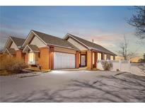 Charming single-Gathering home with a two-car garage, brick accents, and a snow-covered yard at 11167 Bryant Mews, Denver, CO 80234
