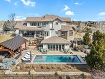 Stunning backyard featuring a pool, outdoor kitchen, and lounge area perfect for entertaining and relaxation at 2960 High Prairie Way, Broomfield, CO 80023