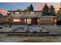 Two-story brick home with attached garage and snow-covered landscaping at 14022 W Alaska Dr, Lakewood, CO 80228