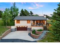 Charming home featuring a two-car garage, a welcoming porch, and landscaped steps to the entry way at 713 Aspen Rd, Golden, CO 80401