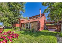 Charming home with a brick and wood exterior, mature landscaping, and a cozy outdoor patio space at 6225 E Mississippi Ave, Denver, CO 80224