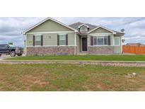 Charming single-Gathering home with stone accents, manicured lawn, and a welcoming facade at 16516 Fairbanks Rd, Platteville, CO 80651