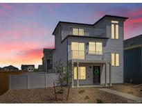Charming two-story home with modern design, balcony, landscaped front yard, and a vibrant sunset at 5147 N Waco St, Denver, CO 80249