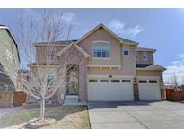 Charming two-story home with a three car garage and inviting front entrance with stone details at 2454 Ambience Ln, Castle Rock, CO 80109