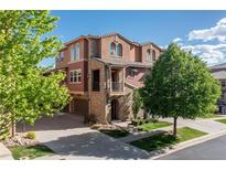 Beautiful two-story home with stone accents, a balcony, a three car garage, and mature trees at 3454 Cascina Pl # D, Highlands Ranch, CO 80126