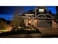 Charming two-story home with a stone facade, manicured lawn, and a two-car garage at twilight at 1312 Pine View Rd, Golden, CO 80403