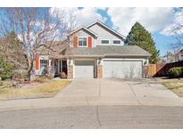 Charming two-story home with a three-car garage, stone accents, and a well-maintained front yard at 8743 Fairview Oaks Ln, Lone Tree, CO 80124