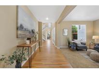 Spacious hallway with hardwood floors, leading to the staircase and multiple rooms at 4821 Bluegate Dr, Highlands Ranch, CO 80130