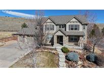 Charming two-story home featuring stone accents, a well-maintained yard, and inviting curb appeal at 7734 Terry Ct, Arvada, CO 80007