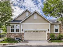 Charming home exterior featuring stone accents, a two-car garage, and well-maintained landscaping at 6924 W Euclid Pl # A, Littleton, CO 80123