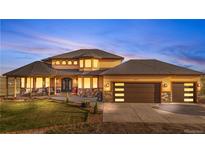 Stunning two-story home boasts a manicured lawn and an attached three-car garage with stone accents at 942 S County Road 129 Rd, Bennett, CO 80102