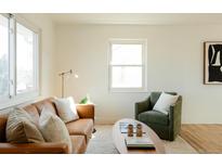 Bright living room features a soft rug, modern furniture, and natural light from windows at 133 S Xavier St, Denver, CO 80219