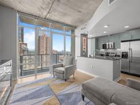 Open-concept living room with floor-to-ceiling windows and a modern kitchen at 891 14Th St # 2505, Denver, CO 80202