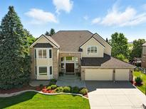 Stunning two-story home featuring a manicured lawn and a three-car garage at 9556 Kemper Dr, Lone Tree, CO 80124