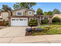 Charming brick and siding home featuring a two-car garage and beautifully landscaped front yard at 18625 E Kent Dr, Aurora, CO 80013