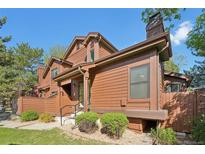 Charming townhouse featuring a wood exterior, landscaped yard, and inviting entryway on a sunny day at 9455 W 81St Ave # A, Arvada, CO 80005