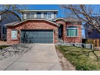 Charming brick home featuring a two-car garage and a well-maintained front yard at 10486 Cheetah Winds, Lone Tree, CO 80124