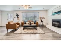 Cozy living room featuring modern furniture, a fireplace, and natural light at 6140 Depew St, Arvada, CO 80003