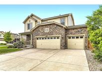 Charming two-story home featuring a stone facade and a three-car attached garage at 6108 S Harvest Ct, Aurora, CO 80016