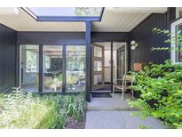 Mid-century modern home with a sleek black exterior and wood entry door at 1398 S Fairfax St, Denver, CO 80222