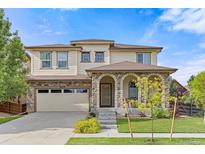 Charming two-story home featuring a stone-accented porch and a well-manicured lawn at 10559 Sedalia St, Commerce City, CO 80022