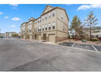 Tan three-story townhome with attached garage and parking at 1143 Autumn Star Pt, Monument, CO 80132