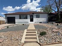 Charming single-story home featuring a lovely rock garden, garage, and well-maintained yard on a sunny day at 716 S Osage St, Denver, CO 80223