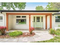 Charming home featuring a light green front door, wood beams, and a well-manicured front yard at 6891 W Eldorado Pl, Lakewood, CO 80227