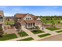 Beautiful two-story home featuring a three-car garage, landscaped yard, and classic architectural details at 848 Sandstone Cir, Erie, CO 80516