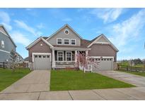 Charming two-story home featuring a manicured lawn and two-car garages, perfect for families at 848 Sandstone Cir, Erie, CO 80516