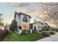 Charming two-story stucco home featuring a quaint balcony, arched windows and manicured landscaping at 4525 King St, Denver, CO 80211